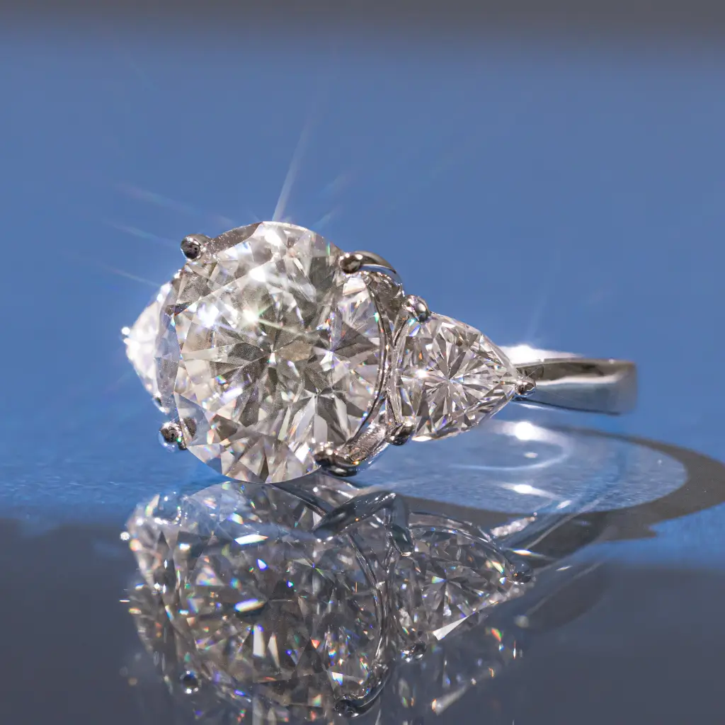 Anel com moissanite central e pedras laterais triangulares cravejadas