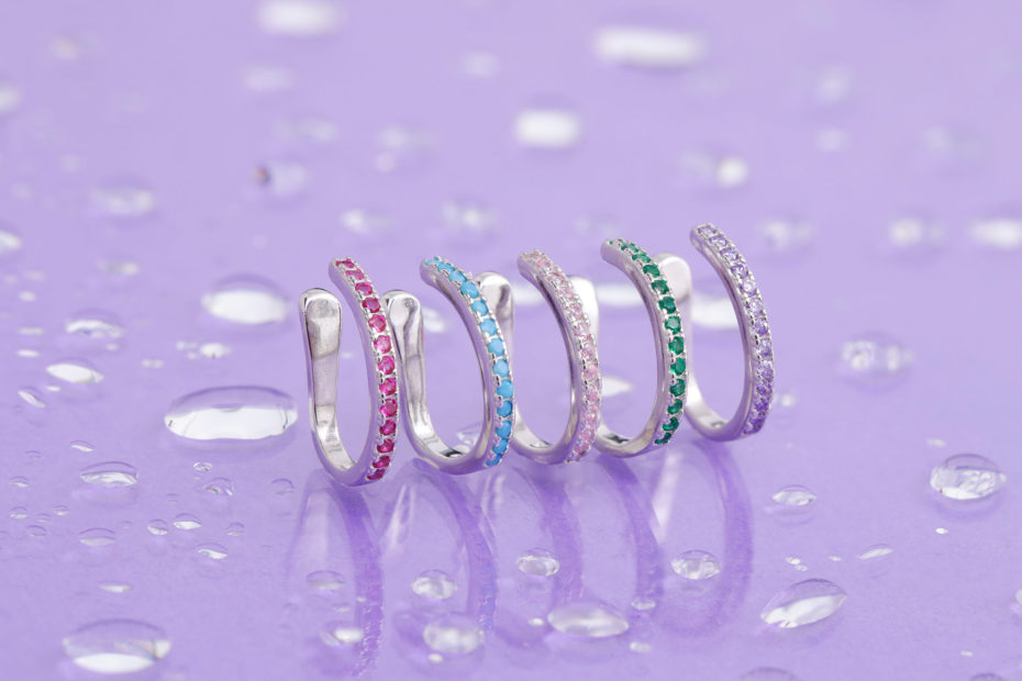 5 anéis alinhados em uma superfície lilás