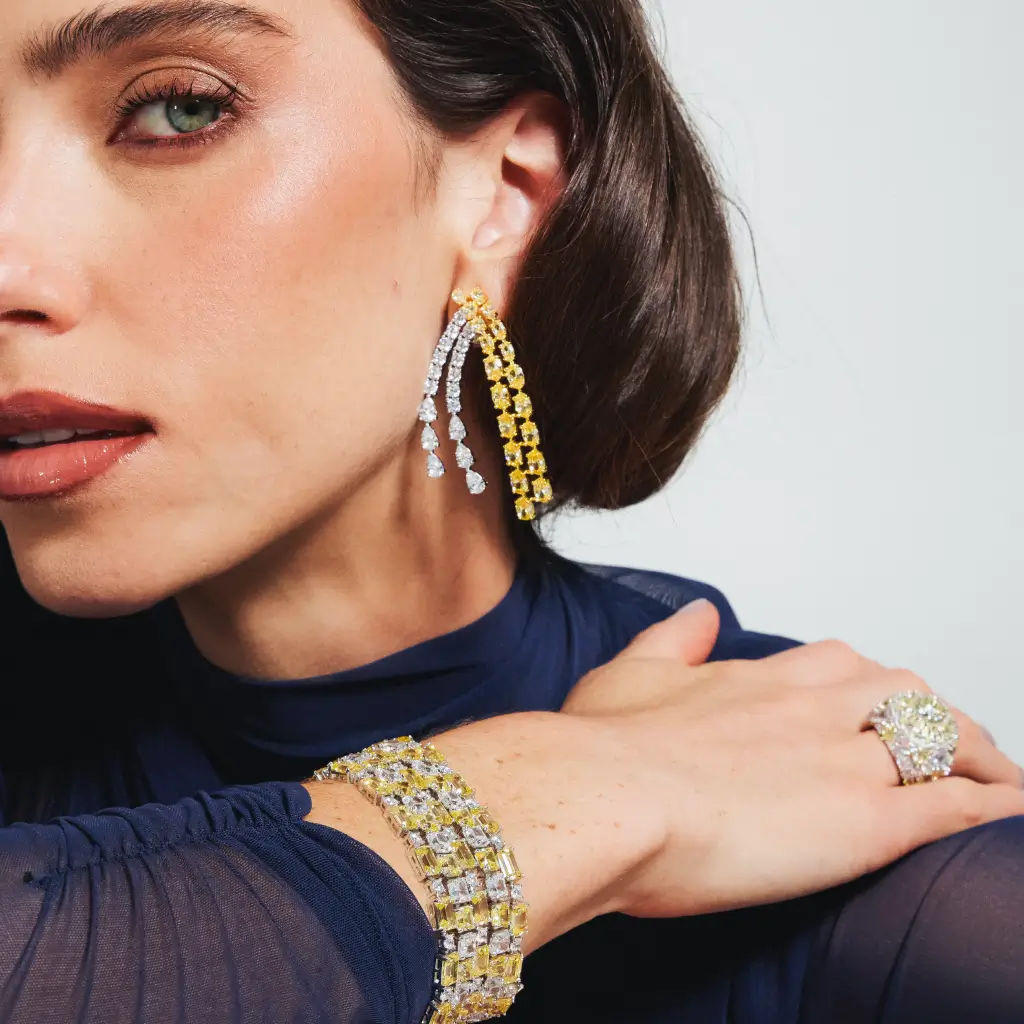 Modelo utilizando um conjunto de brincos statement e pulseira com um mix de cores