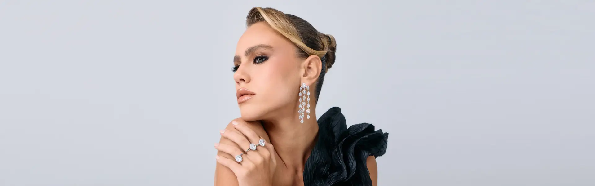Modelo utilizando brinco statement com franjas e anéis com zircônias em prata