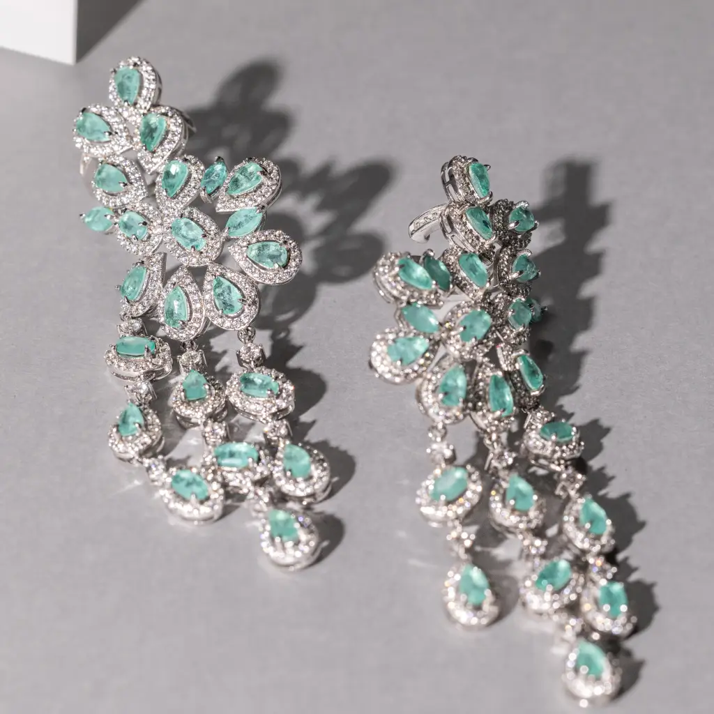 Brincos statement com pedras verdes em formato floral e franja em prata